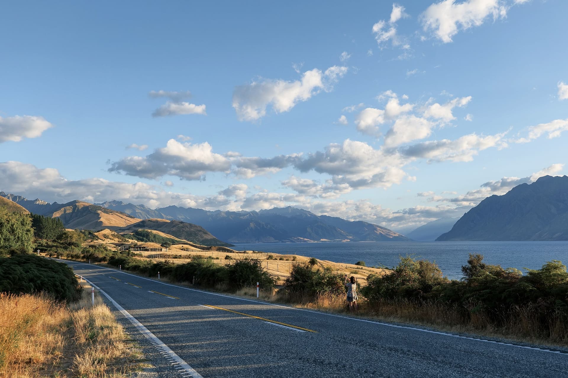A road running beside a lake towards the mountains