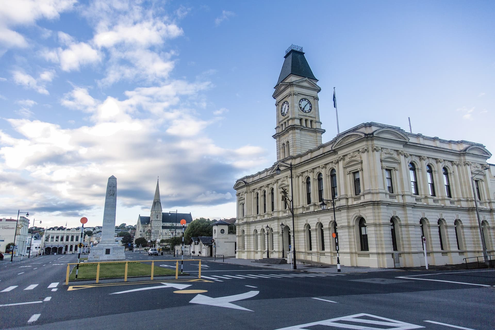 A historic civic building with a clock tower under a partly cloudy sky