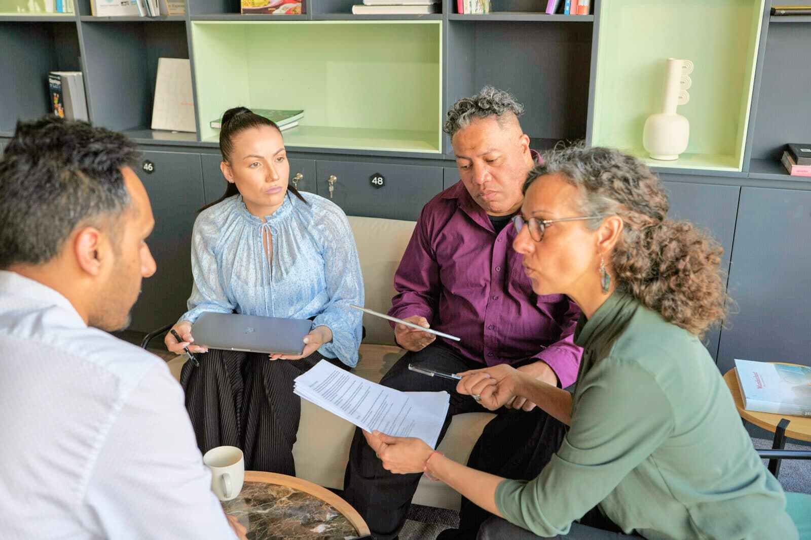 Four colleagues reading through papers together